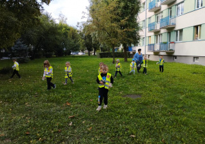 Dzieci szukają śmieci na trawniku