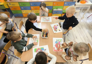 Dzieci kolorują przy stoliku.
