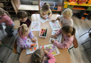 Dzieci kolorują przy stoliku.