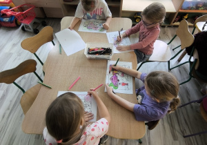 Dzieci kolorują przy stoliku.