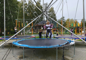 Dzieci skaczą na dużych trampolinach