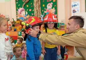 Przedszkolaki stoją w kaskach.