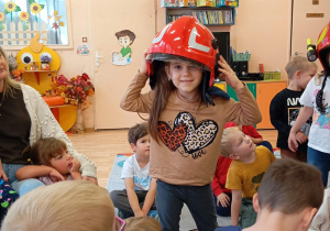 Dziewczynka stoi ubrana w kask.