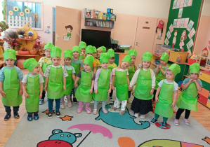 Przedszkolaki stoją w strojach kucharskich.