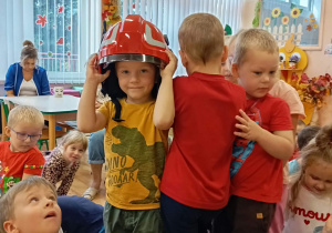 Chłopiec przymierza hełm strazacki