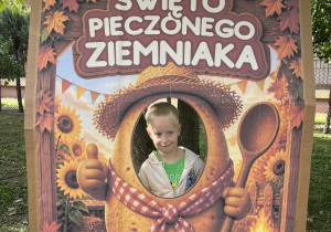 Chłopiec uśmiecha się w ziemniaczanej fotobudce przygotowanej na Święto Pieczonego Ziemniaka.