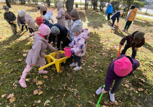 Dzieci wykonują prace ogrodowe.