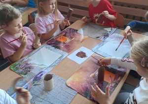 Dzieci malują farbami papierowe rolki
