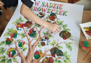Dzieci wykonują prace plastyczne inspirowane jabłkami.