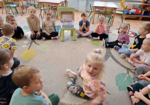 Dzieci siedzą w kole i słuchają opowieści o Ciszakach