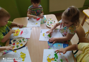 Dzieci malują paluszkami maczanymi w farbie Marzannę