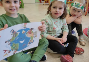 Dzieci pokazują ilustrację "szczęśliwej" Ziemi.