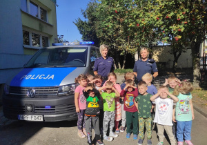 Grupa dzieci pozuje do zdjęcia z Paniami Policjantkami.