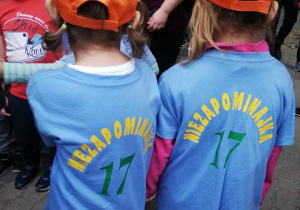 Dziewczynki stoją ubrane w koszulki z nazwą przedszkola