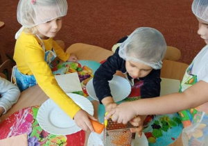 Dzieci ścierają marchewkę na surówkę