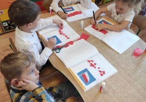 Dzieci wyklejają flagę Polski.
