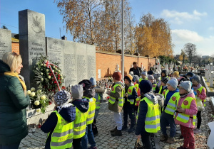 Dzieci stoją przy grobie nieznanych żołnierzy