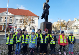 Dzieci z grupy III stoją przy pomniku Józefa Piłsudskiego.