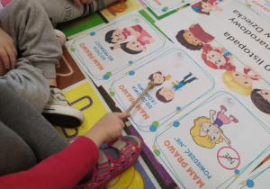 Dziewczynka wskazuje obrazek przedstawiający prawa dzieci
