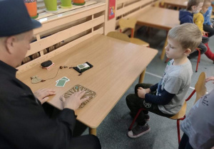 Iluzjonista pokazuje chłopcu sztuczki przy stoliku