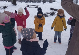 dzieci bawią się w ogrodzie przedszkolnym na śniegu