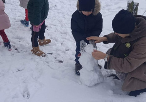 dzieci bawią się w ogrodzie przedszkolnym na śniegu