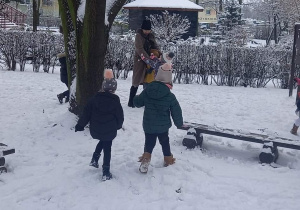 dzieci bawią się w ogrodzie przedszkolnym na śniegu