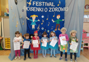 Uczestnicy festiwalu pozują do pamiątkowego zdjęcia z pamiątkowymi dyplomami